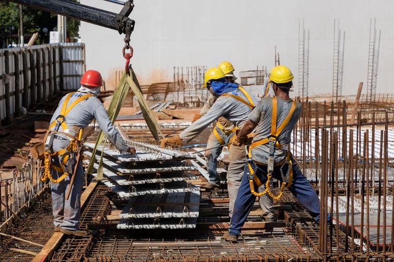 Men from the construction industry, working on the work of a building under construction. Placing slab pieces made with steel and concrete.
