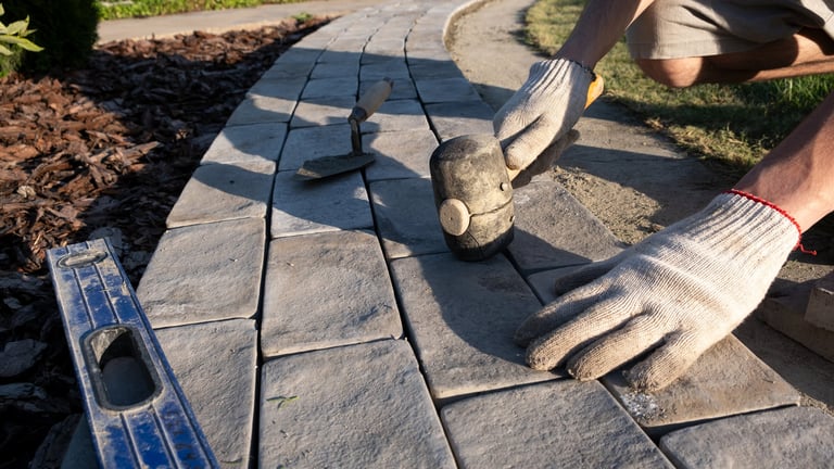 Laying paving stones on cement mortar. Laying a garden path made of tiles. Self-laying of concrete paving slabs in the courtyard of the house. do it yourself. DIY. Spatula, level, mallet